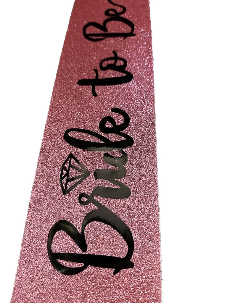 Pembe Üzeri Siyah İtalik Alyanslı Bride To Be Yazılı Simli Işıltılı Kuşak Kemer 10x80 cm Pembe Üzeri Siyah İtalik Alyanslı Bride To Be Yazılı Simli Işıltılı Kuşak Kemer 10x80 cm